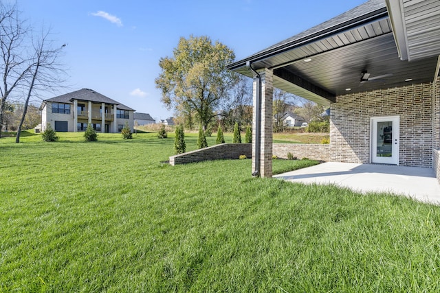 view of yard with ceiling fan and a patio area