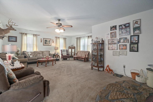 carpeted living room featuring ceiling fan and a textured ceiling