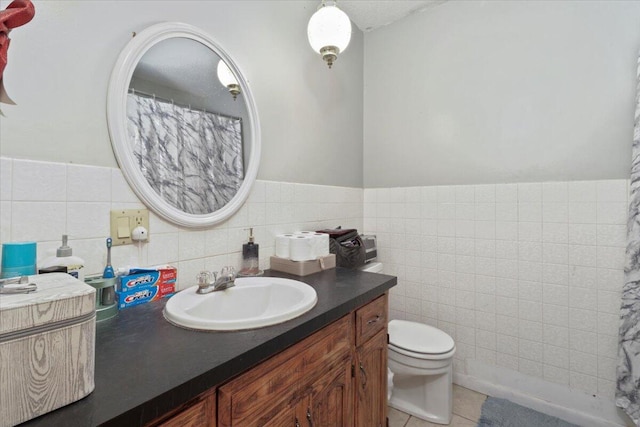 bathroom with tile patterned floors, vanity, tile walls, and toilet