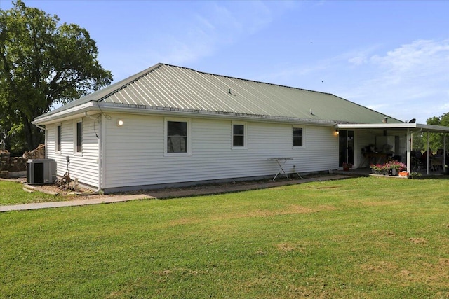 rear view of property with a yard and central air condition unit