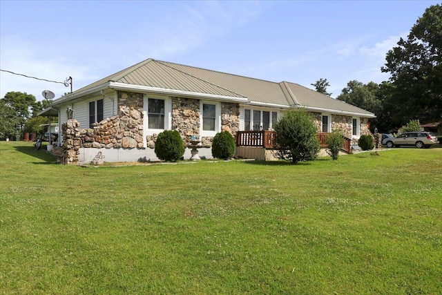 ranch-style home featuring a front lawn and a wooden deck