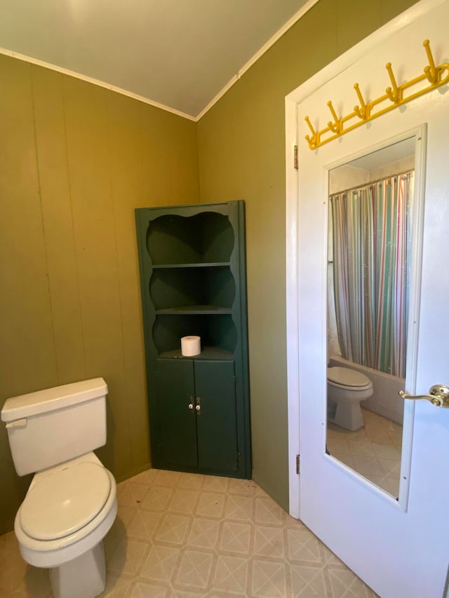 bathroom featuring ornamental molding, shower / tub combo with curtain, and toilet