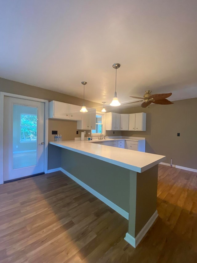 kitchen with white cabinets, kitchen peninsula, and dark hardwood / wood-style flooring