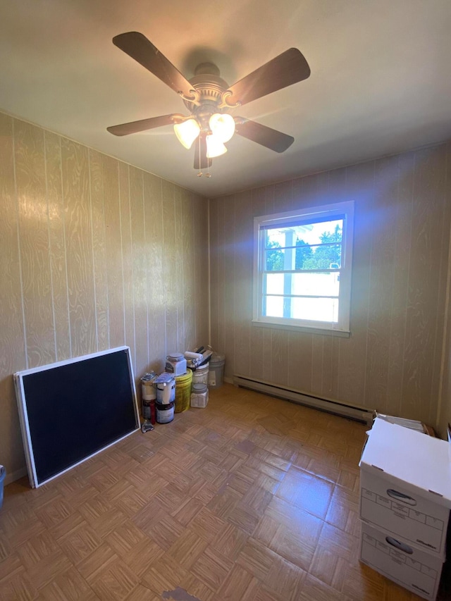 unfurnished room with light parquet floors, ceiling fan, and a baseboard radiator