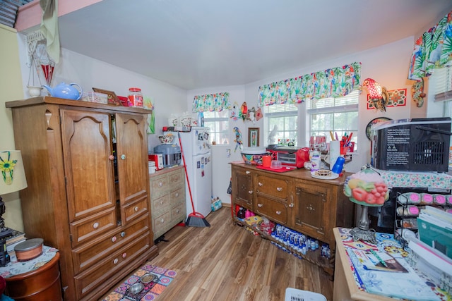 bedroom featuring light hardwood / wood-style flooring and white refrigerator