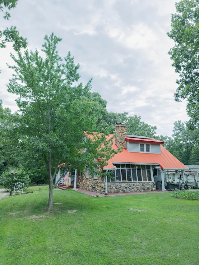 view of front of house featuring a sunroom and a front yard