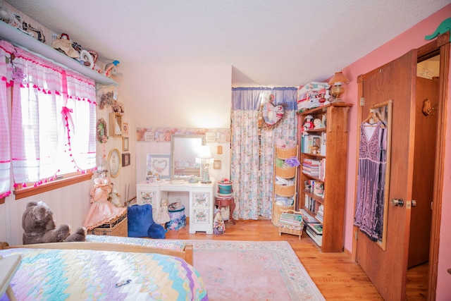 bedroom with a textured ceiling and light hardwood / wood-style flooring