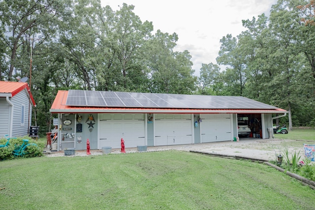 garage with solar panels and a lawn