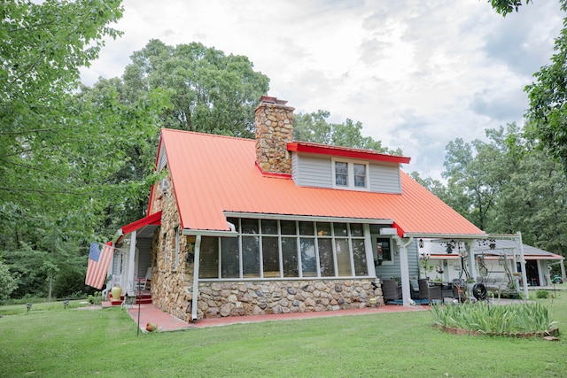 back of house featuring a patio area, a sunroom, and a yard