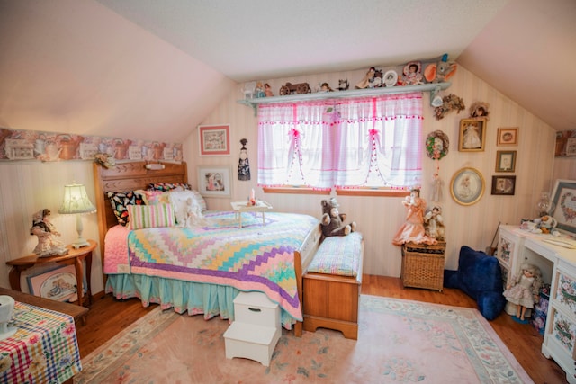 bedroom with vaulted ceiling and hardwood / wood-style flooring