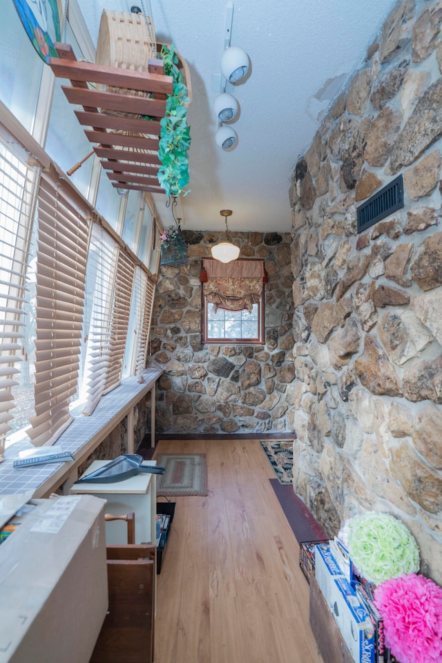 interior space featuring hardwood / wood-style flooring and a textured ceiling