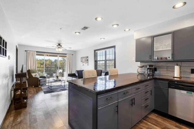 kitchen featuring dishwasher, dark wood-type flooring, kitchen peninsula, and gray cabinetry