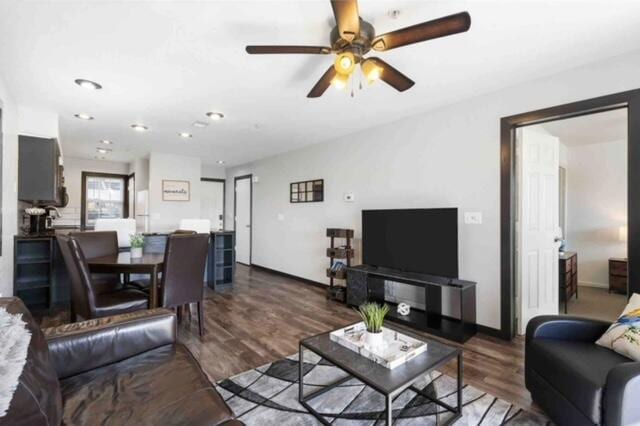 living room featuring dark hardwood / wood-style flooring and ceiling fan