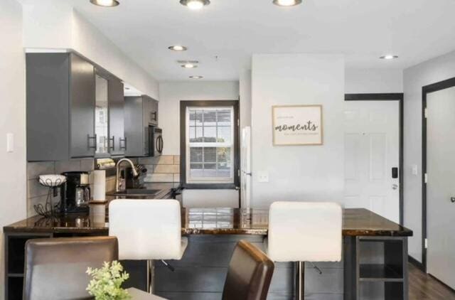 kitchen with tasteful backsplash, sink, and dark hardwood / wood-style flooring