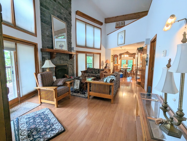 living room with plenty of natural light, high vaulted ceiling, and light wood-type flooring