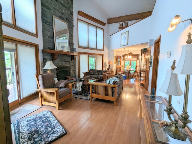 living area with beamed ceiling, wood finished floors, a wealth of natural light, and high vaulted ceiling