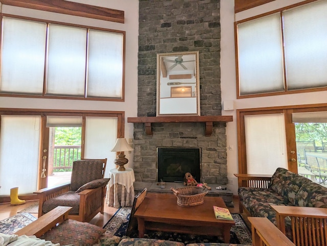living room with a stone fireplace and a towering ceiling