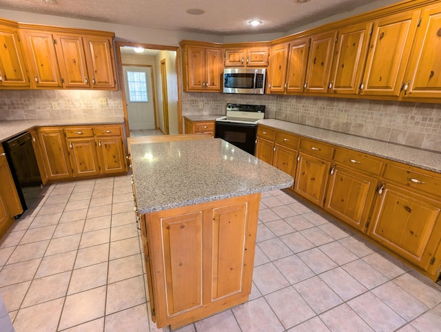 kitchen with a center island, light tile patterned floors, dishwasher, electric range oven, and stainless steel microwave