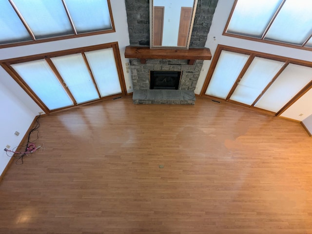 unfurnished living room featuring visible vents, baseboards, wood finished floors, and a fireplace