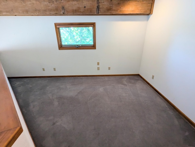 carpeted empty room featuring baseboards