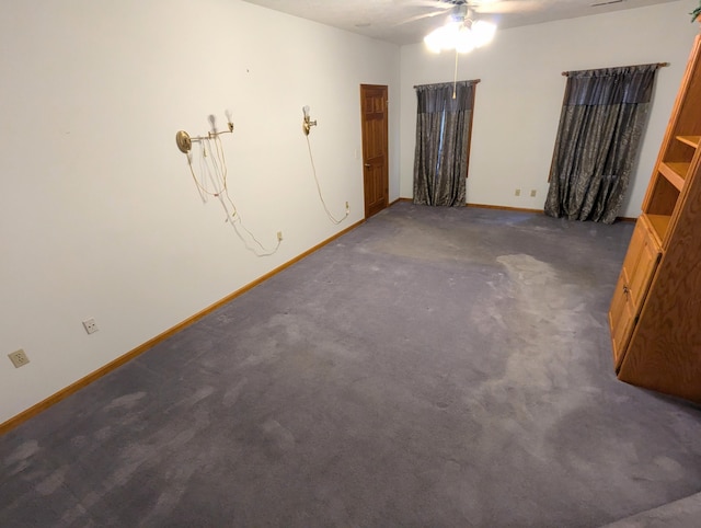 spare room featuring dark carpet, a ceiling fan, and baseboards