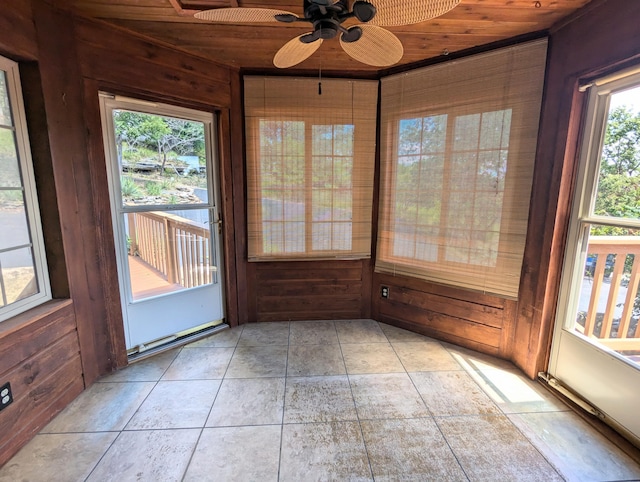 unfurnished sunroom featuring a healthy amount of sunlight, wood walls, and wooden ceiling