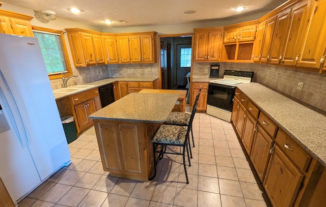 kitchen featuring dishwasher, a sink, a kitchen island, electric range oven, and white refrigerator with ice dispenser