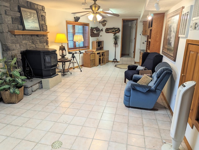 living room featuring ceiling fan, a textured ceiling, light tile patterned floors, and a wood stove