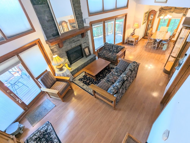 living room featuring a towering ceiling, hardwood / wood-style floors, and a fireplace