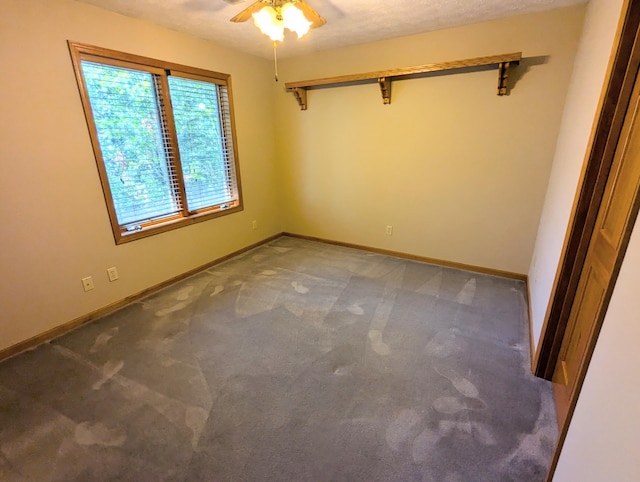 carpeted empty room with ceiling fan and a textured ceiling