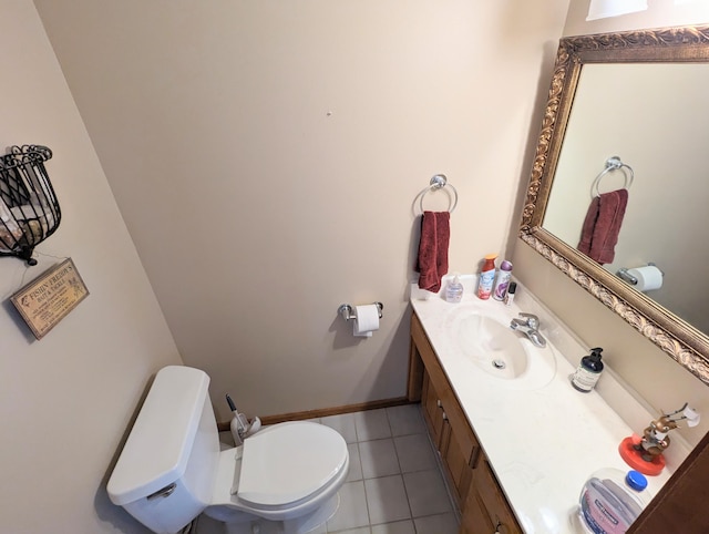 bathroom featuring baseboards, vanity, tile patterned flooring, and toilet
