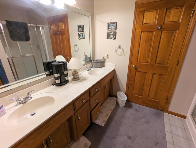 bathroom featuring tile patterned flooring, a sink, double vanity, and a stall shower