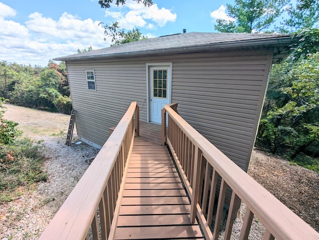 rear view of property featuring a shingled roof