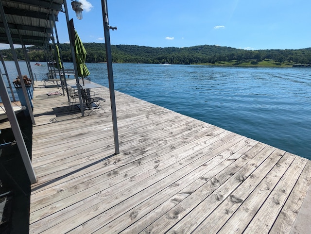 view of dock featuring a view of trees and a water view