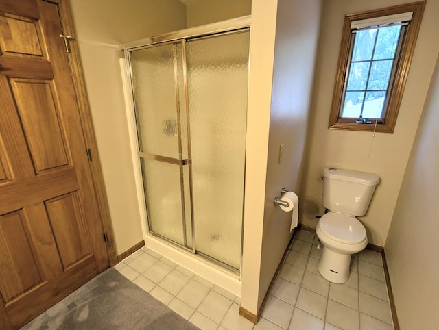 bathroom with a shower with shower door, toilet, and tile patterned flooring