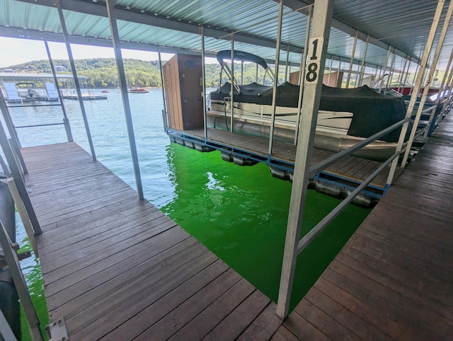 view of dock with boat lift and a water view