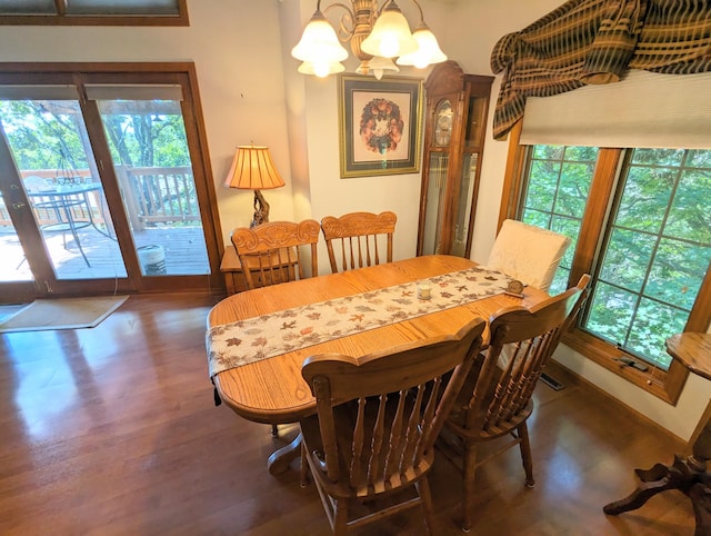 dining area featuring a chandelier, plenty of natural light, baseboards, and wood finished floors