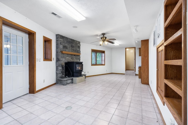 127 Kachina Trl, Branson West, MO 65737 - unfurnished living room featuring a ceiling fan, baseboards, and a wood stove
