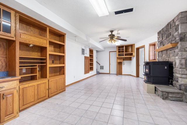 127 Kachina Trl, Branson West, MO 65737 - unfurnished living room with a wood stove, a ceiling fan, baseboards, and light tile patterned floors