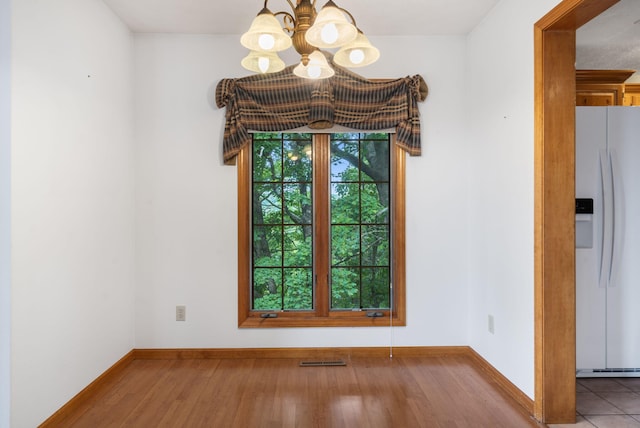 127 Kachina Trl, Branson West, MO 65737 - unfurnished dining area with a chandelier, baseboards, and wood finished floors