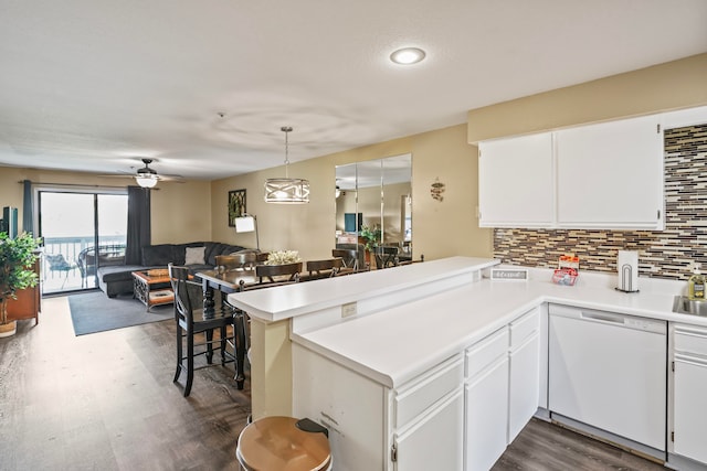 kitchen with dark hardwood / wood-style flooring, decorative light fixtures, dishwasher, kitchen peninsula, and white cabinets