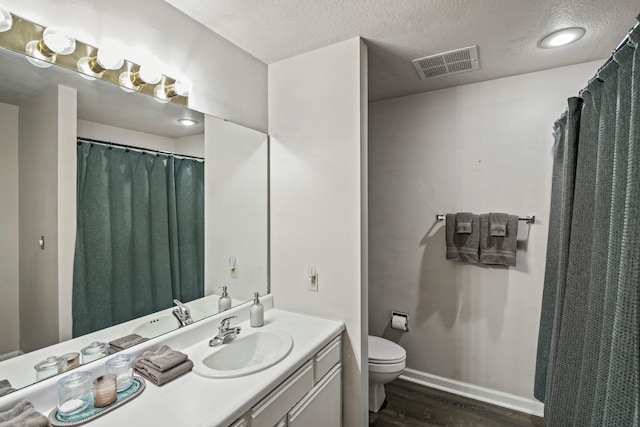 170 Bunker Ridge Dr Unit 6, Branson, MO 65616 - full bath with wood finished floors, visible vents, toilet, vanity, and a textured ceiling