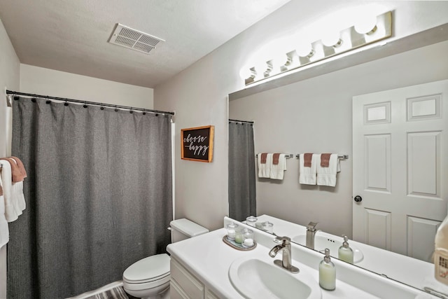 bathroom with vanity, toilet, and a textured ceiling