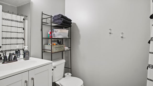 bathroom with vanity, toilet, a textured ceiling, and a shower with shower curtain