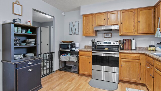 kitchen featuring light hardwood / wood-style floors, appliances with stainless steel finishes, and a textured ceiling