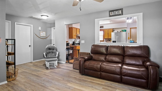 living room with light hardwood / wood-style floors and ceiling fan