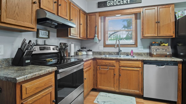 kitchen featuring appliances with stainless steel finishes, sink, and light hardwood / wood-style floors