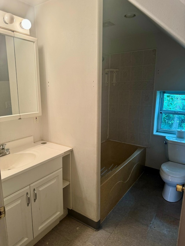 full bathroom with tiled shower / bath, vanity, and toilet