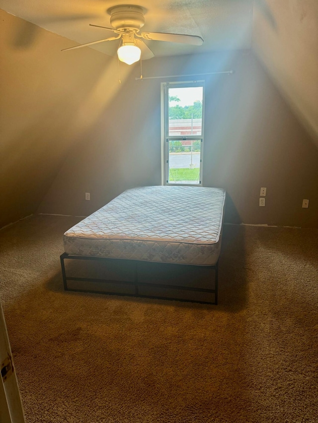 bedroom with ceiling fan, carpet flooring, and vaulted ceiling