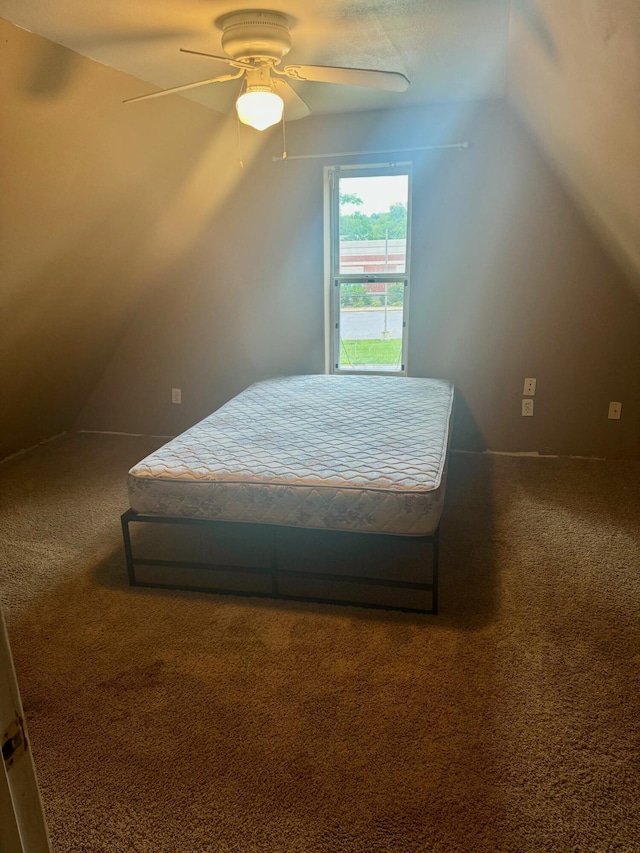 bedroom with dark carpet, lofted ceiling, and a ceiling fan
